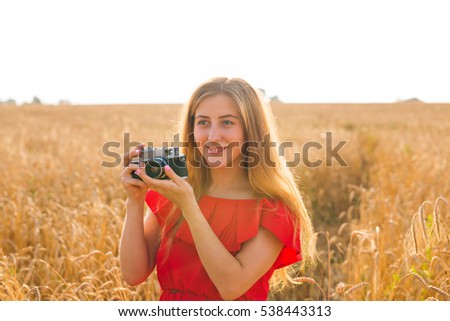 female photographer in the field with a camera taking pictures