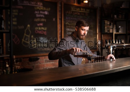 Attractive bartender is pouring a shots Royalty-Free Stock Photo #538506688