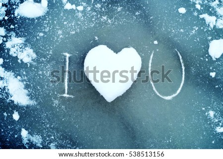 Heart from snow on ice. Snow Heart and text "I love you". Love concept. Valentine background.