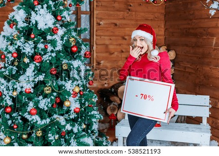 Laugh nice girl holding  -70% sale banner. Christmas and New year are coming. Discounts everywhere.