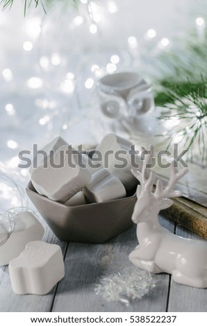 Plate with marshmallow in the winter still life with lights and reindeer figurine