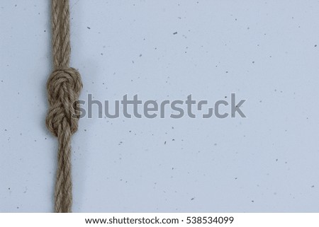Rope with figure-eight knot border on white sparkle texture background; white copy space for text