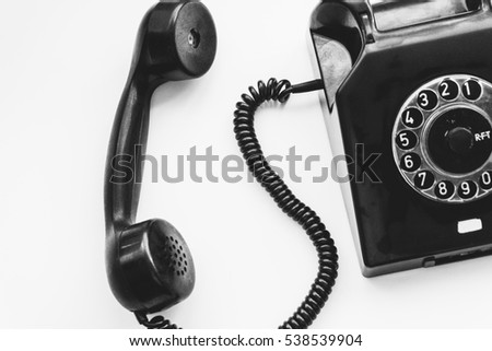 Black retro phone on a white background with rotary dial