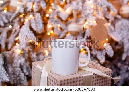 Mug for mockup near christmas tree and gift boxes