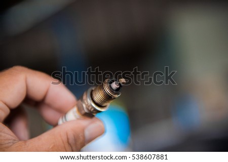 The proper installation of a spark-plug in a car , Spark car engine, black background.
