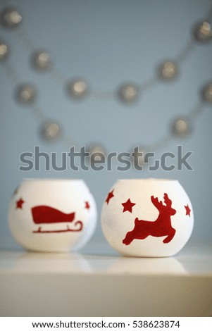 Christmas candles with deer and sleds pictured on it