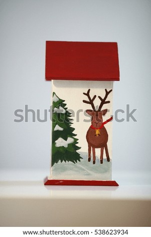 Traditional Christmas decorations and toys. Wooden house with Christmas trees painted on it