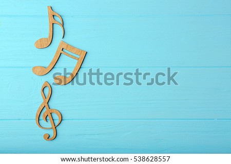 Music notes on color wooden background