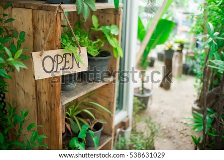 vintage Wooden board sign that says Open  in front of the door at restaurant and coffee shop .