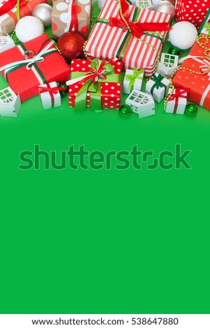 Christmas presents in red packaging. Satin colored ribbons. Green background.