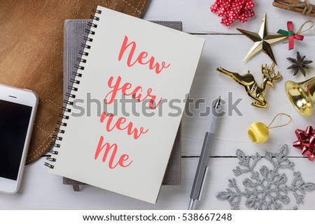 Notebook with New year new me massage and colorful decoration objects.