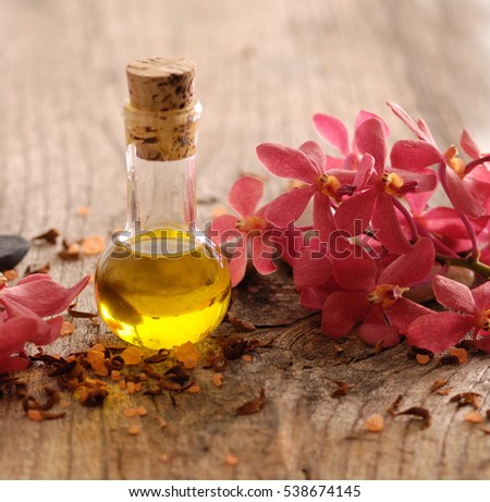 Branch red orchid with massage oil ,stone on old wood