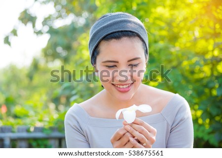 Beautiful asian girl with flower in park with sun light