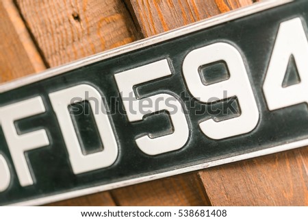 Car license plate on a wooden wall