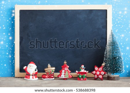 Christmas decoration with blackboard on blue wooden background with snow in vintage color filter