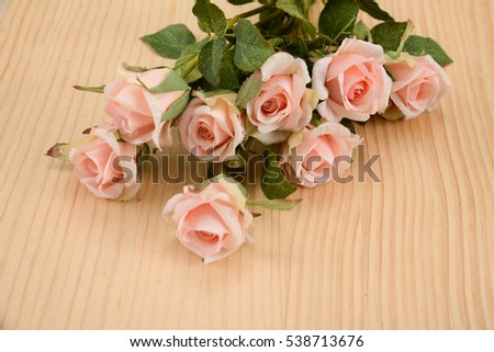 Bouquet of pink roses lying on wooden boards