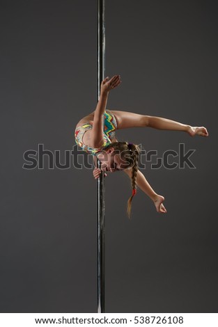 Junior girl balancing on pylon at dance studio