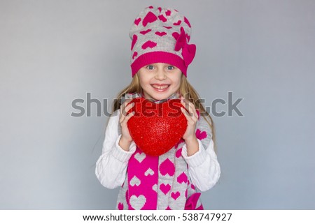 portrait of a little girl with a heart in the hands of the holiday Valentine's Day