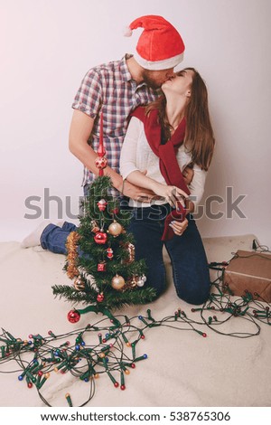loving couple decorating Christmas tree. uses communication. give gifts