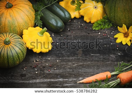 Fresh organic seasonal vegetables - pumpkin, squash, carrots on wooden background, toned image, selective focus and top view