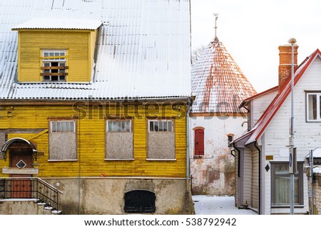 Architectural diversity in centre of resort Estonian town Parnu. Historic white old tower in courtyard of old town. Snow-covered streets of tourist Baltic city in winter