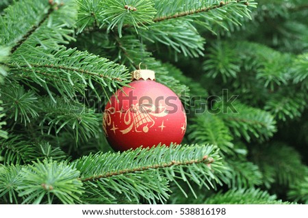 Closeup of Green Christmas tree and red ball decorations.