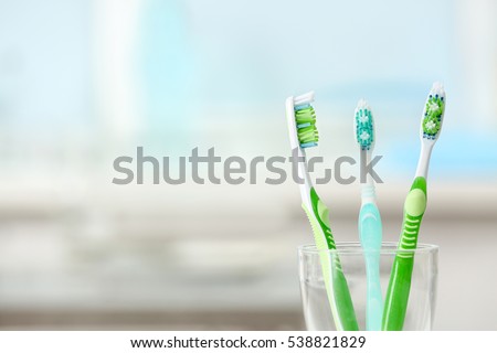 Toothbrushes in glass on blurred background Royalty-Free Stock Photo #538821829