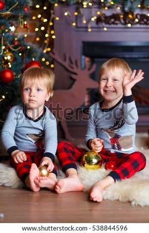two brothers, blond with blue eyes near the Christmas tree . new Year. Christmas