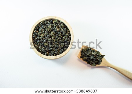 Oolong tea in wood bowl on white background.