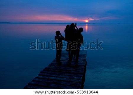 People shot photo on sunset in the color sky under water lake.