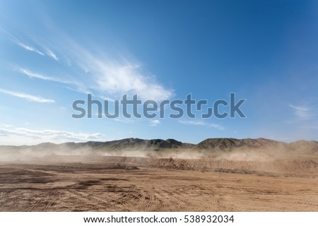 the dust was blowing in busy construction site against a blue sky Royalty-Free Stock Photo #538932034