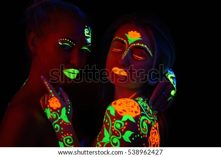 two girls in neon light pictures neon colors on the body, fire and ice