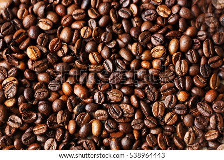A large pile of scattered ripe brown coffee beans.