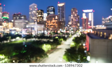 Blurred abstract with bokeh light downtown Houston illuminated at blue hour with green city park and modern skylines light. The most populous city in Texas and fourth-most in America. Panorama view.