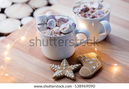 Two Cups of hot chocolate with murshmallows and Christmas wooden background
