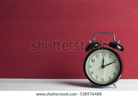 Still life, Retro black clock on white table and red grunge background. Royalty-Free Stock Photo #538976488