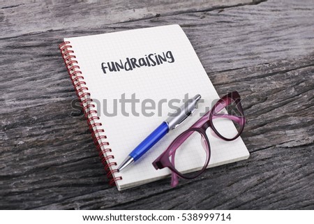 Note with fundraising on the wooden background