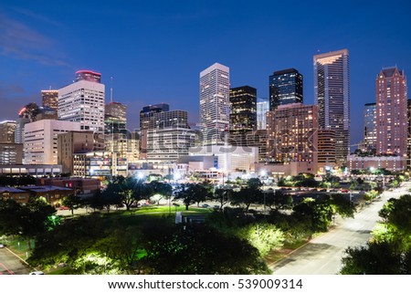 Aerial view downtown Houston illuminated at blue hour with green city park and modern skylines light. The most populous city in Texas, fourth-most in United States. Architecture and travel background.