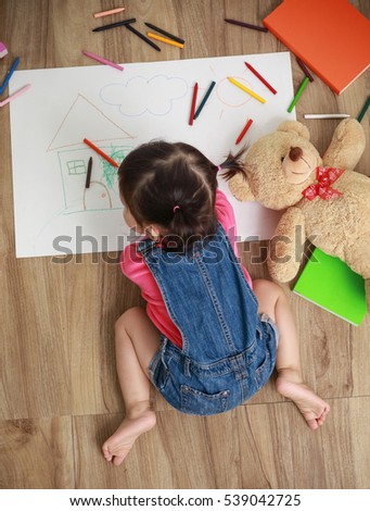 Little Asian girl drawing in paper on floor indoors, Baby healthy and preschool concept