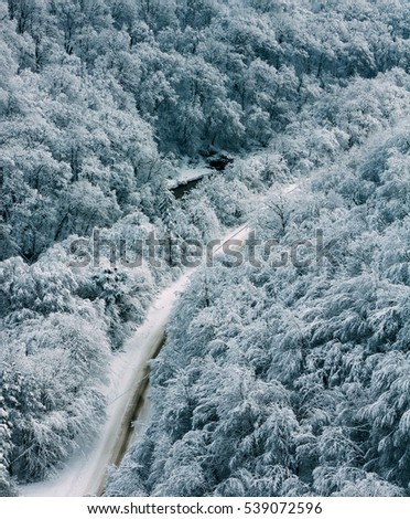 winter landscape mountain road in forest, top view, tinted photowinter landscape with a road in the forest top view, tinted photo.