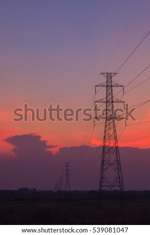 Silhouette of high voltage electricity poles at sunset twilight background
