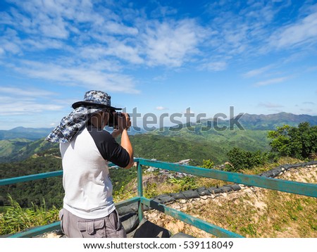 Photographer is taking a picture of scenic landscape