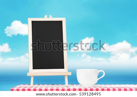 Blackboard menu with coffee cup display on fabric tabletop with blurry bright sky and water wave ocean outdoor seascape background for add your text or banner.