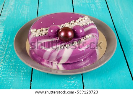 purple mousse cake with mirror glaze with blackberries, blueberries and coconut filling