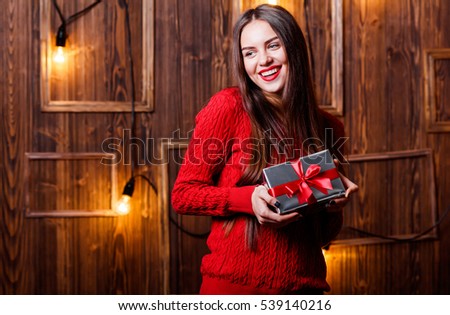 Happy woman in Santa hat with Christmas gift
