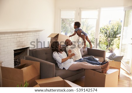 Parents Take A Break On Sofa With Son On Moving Day Royalty-Free Stock Photo #539142574