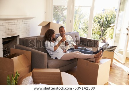 Couple On Sofa Taking A Break From Unpacking On Moving Day Royalty-Free Stock Photo #539142589