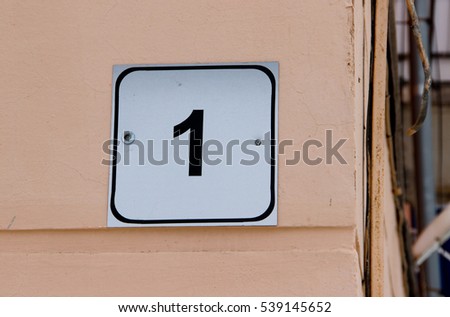 House number one. Black lettering on a white metal plate