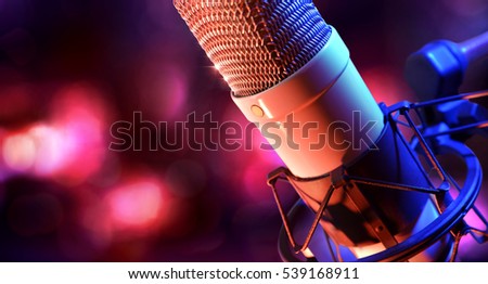Close up studio condenser microphone on stand and anti-vibration mount.  Live recording with colored lights background. Side view
