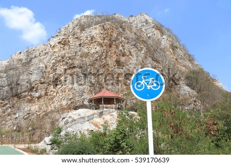 Round bicycle lane sign for bike route in the public park background with stone mountain